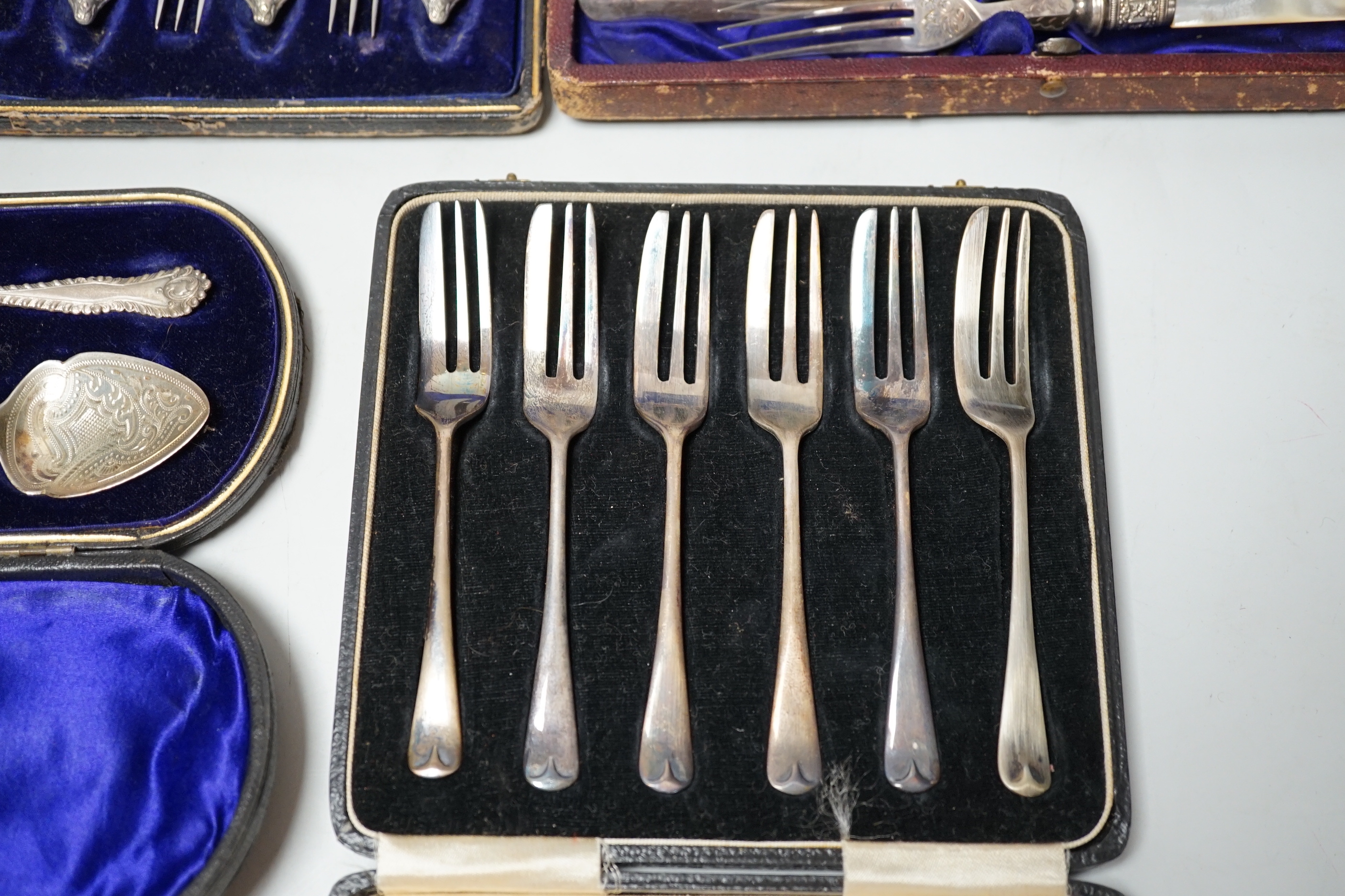 Two cased sets of silver flatware including teaspoons and pair of small servers and two cased sets of plated flatware.